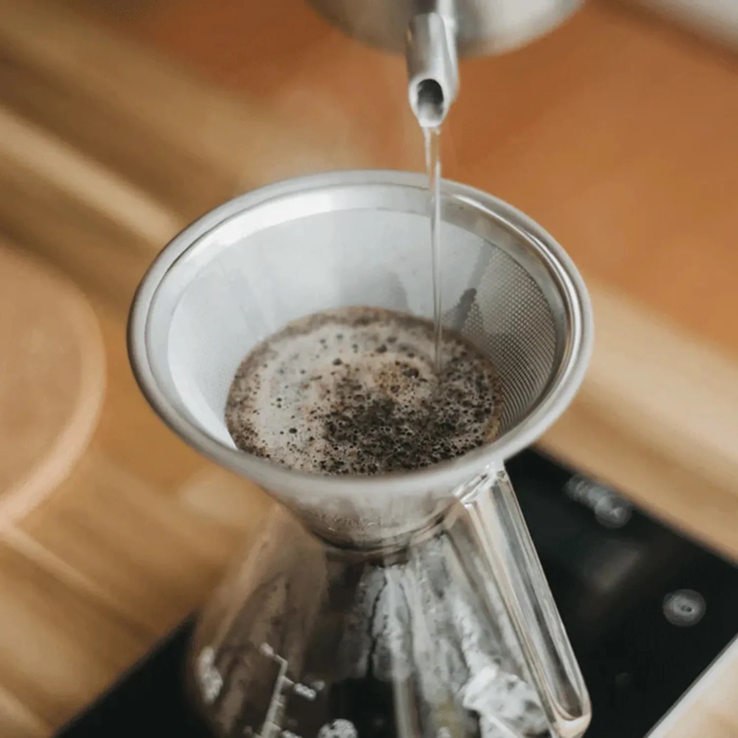 Coffee-making setup with Ovalware filters, kettle, and carafe on a wooden table