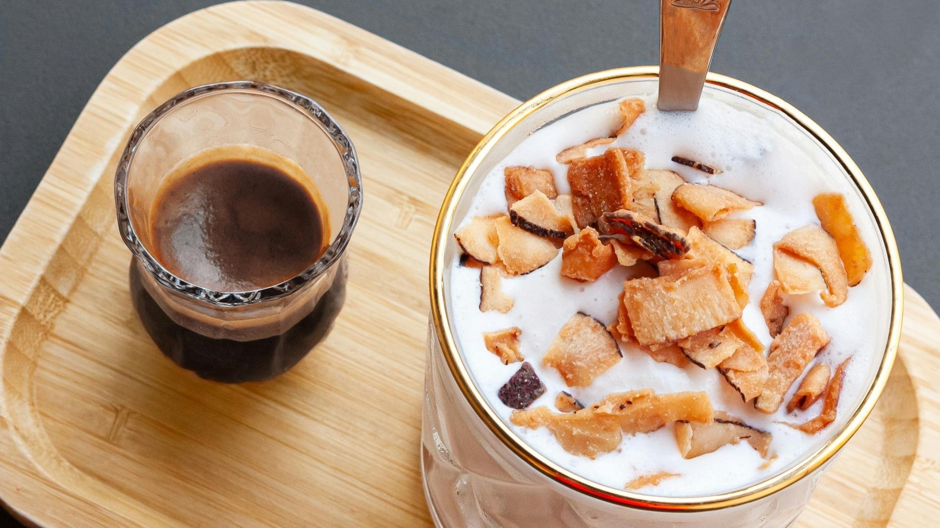 Cloud coffee — coconut water iced coffee with frothy milk float on wooden tray