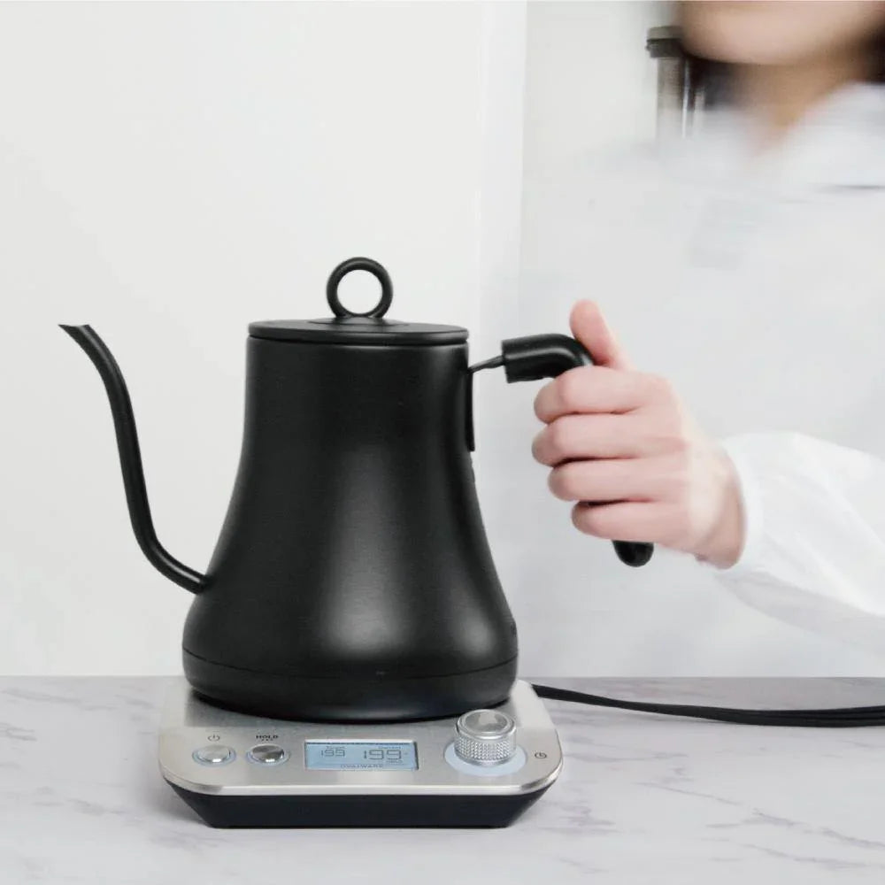Electric kettle lifted off its base, emphasizing cordless design